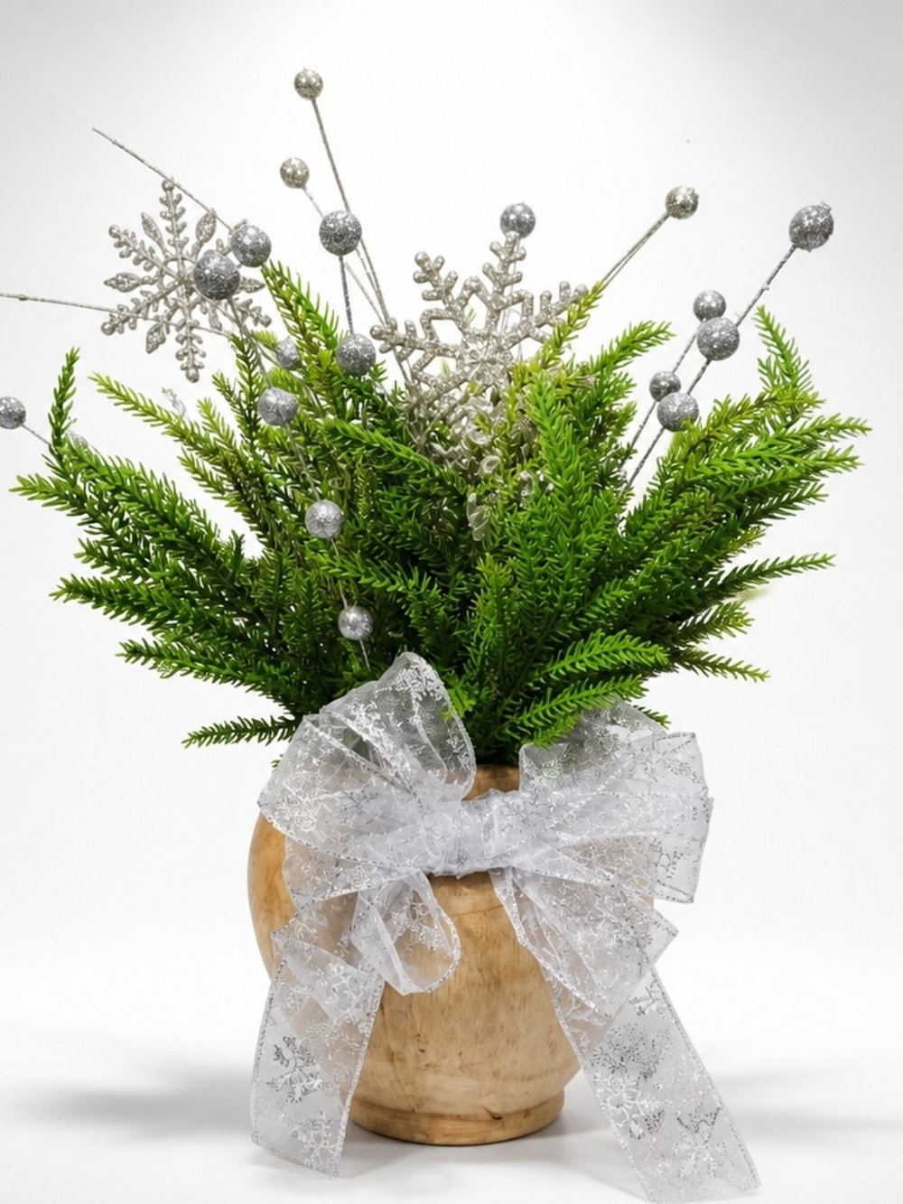 Green Faux Pine Arrangement with Silver Accents and Bow In Raw Wood Vase